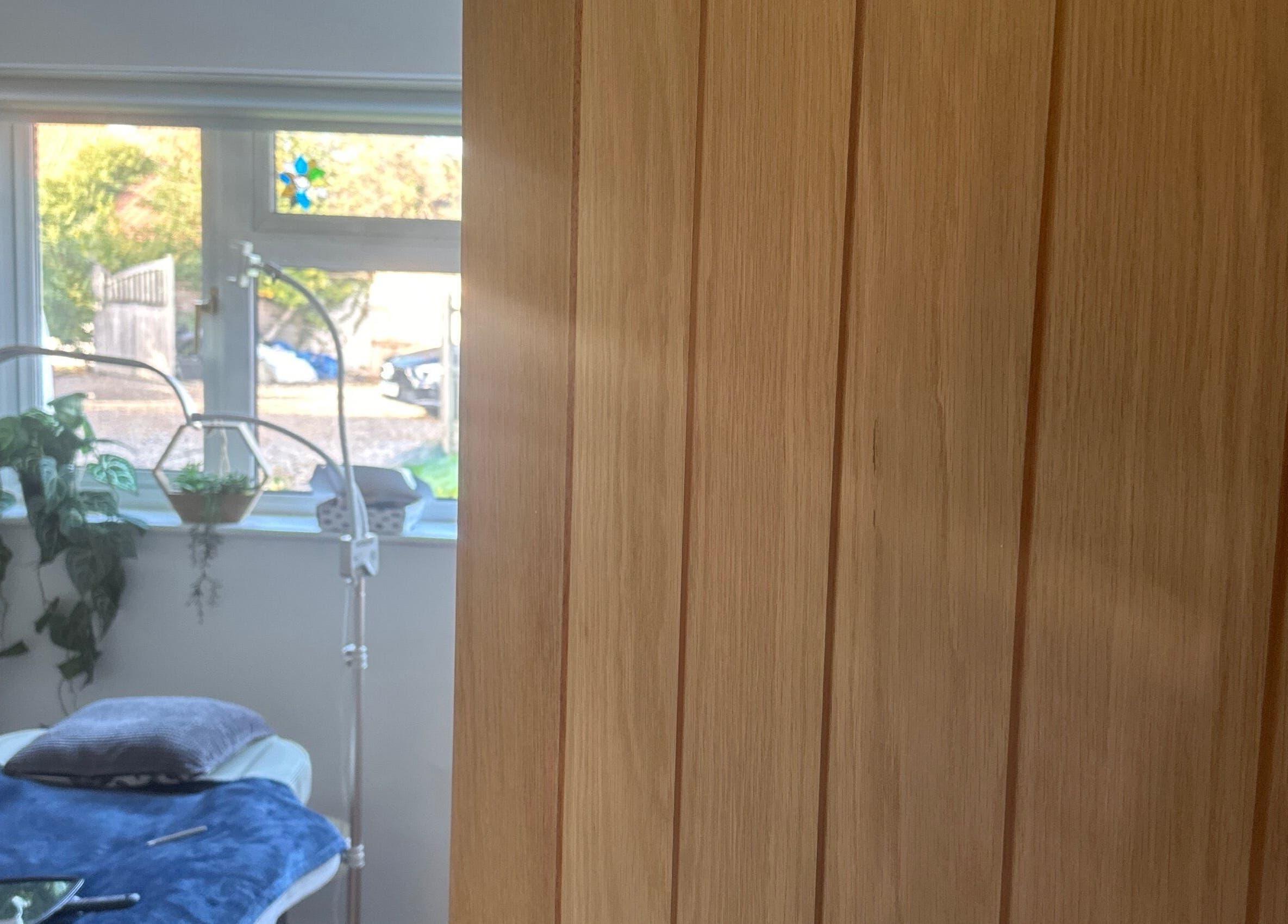 Relaxing treatment room at Edge Nurse Aesthetics, East Harling, England, GB with natural light and plants.