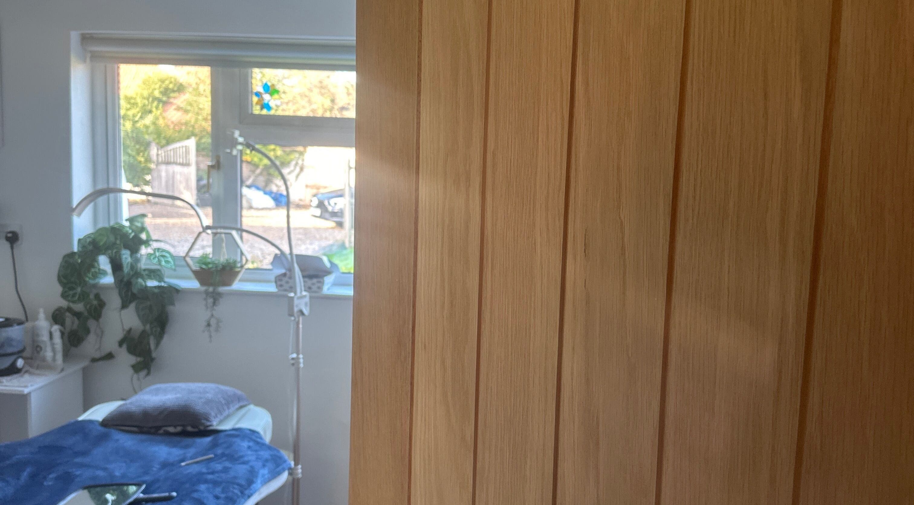 Relaxing treatment room at Edge Nurse Aesthetics, East Harling, England, GB with natural light and plants.