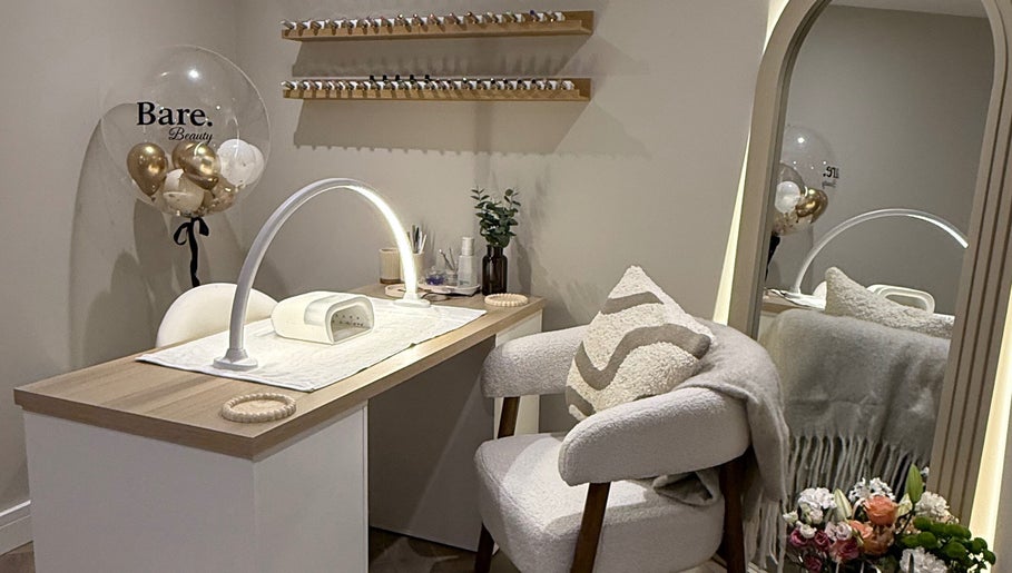 Elegant nail station at BARE Beauty, Birstall, England, GB, featuring cozy seating and nail polish display.