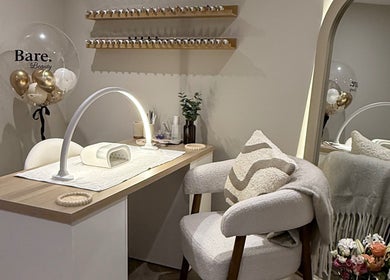 Elegant nail station at BARE Beauty, Birstall, England, GB, featuring cozy seating and nail polish display.