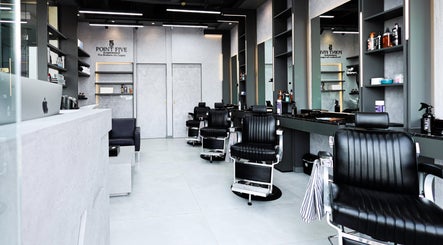 Modern interior of Point Five Barbershop, Dubai, AE with sleek black chairs and contemporary decor.