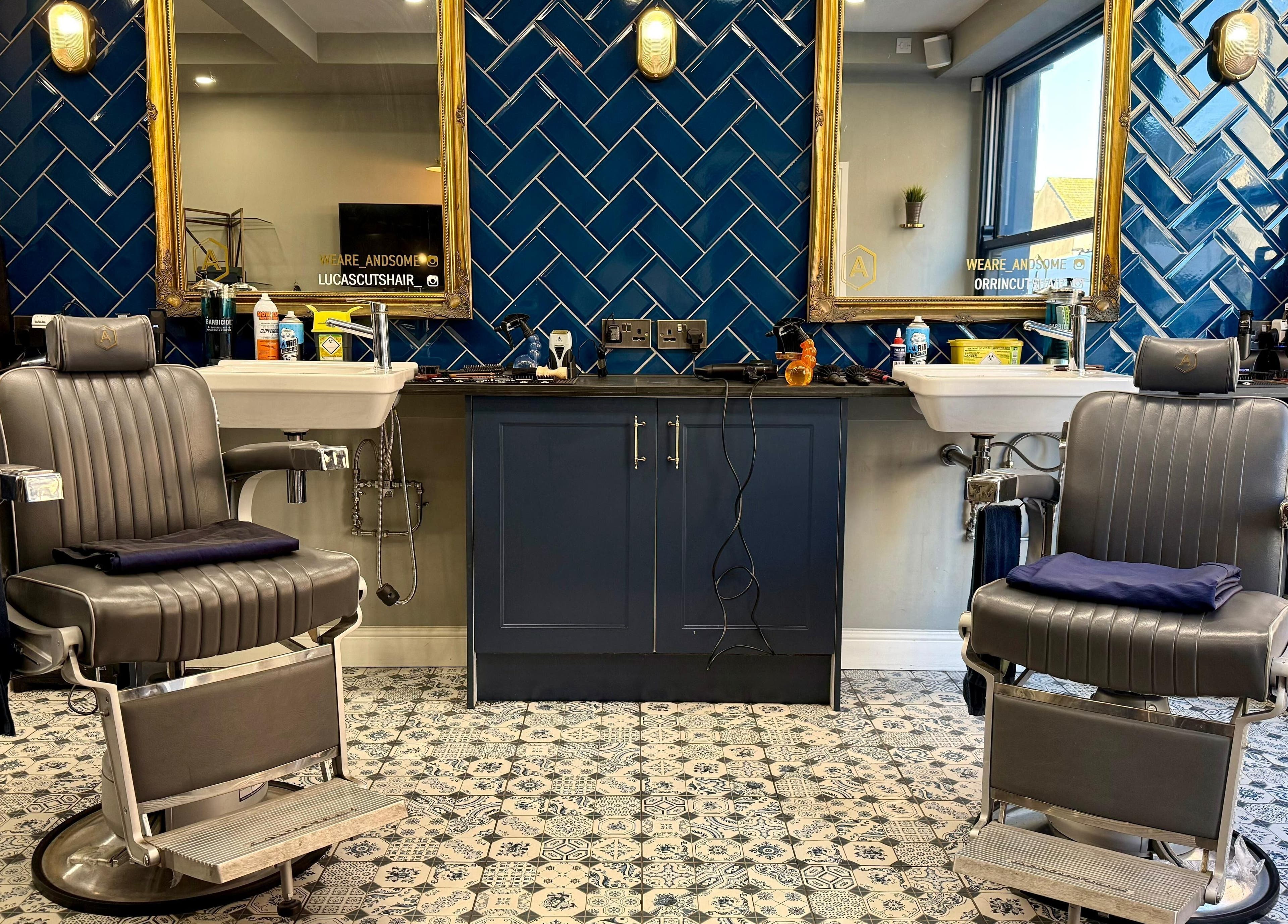 Modern barber chairs at Andsome, Blackpool, England, GB, with stylish tile and mirror backdrop.