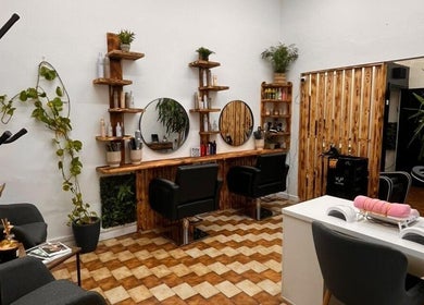 Stylish salon setup at Sanela haircraft, Drogheda, County Louth, IE, featuring sleek chairs and plant decor.