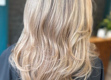 Blonde hair with subtle layers and soft curls at Haute Hair, Cheadle Hulme, England, GB.