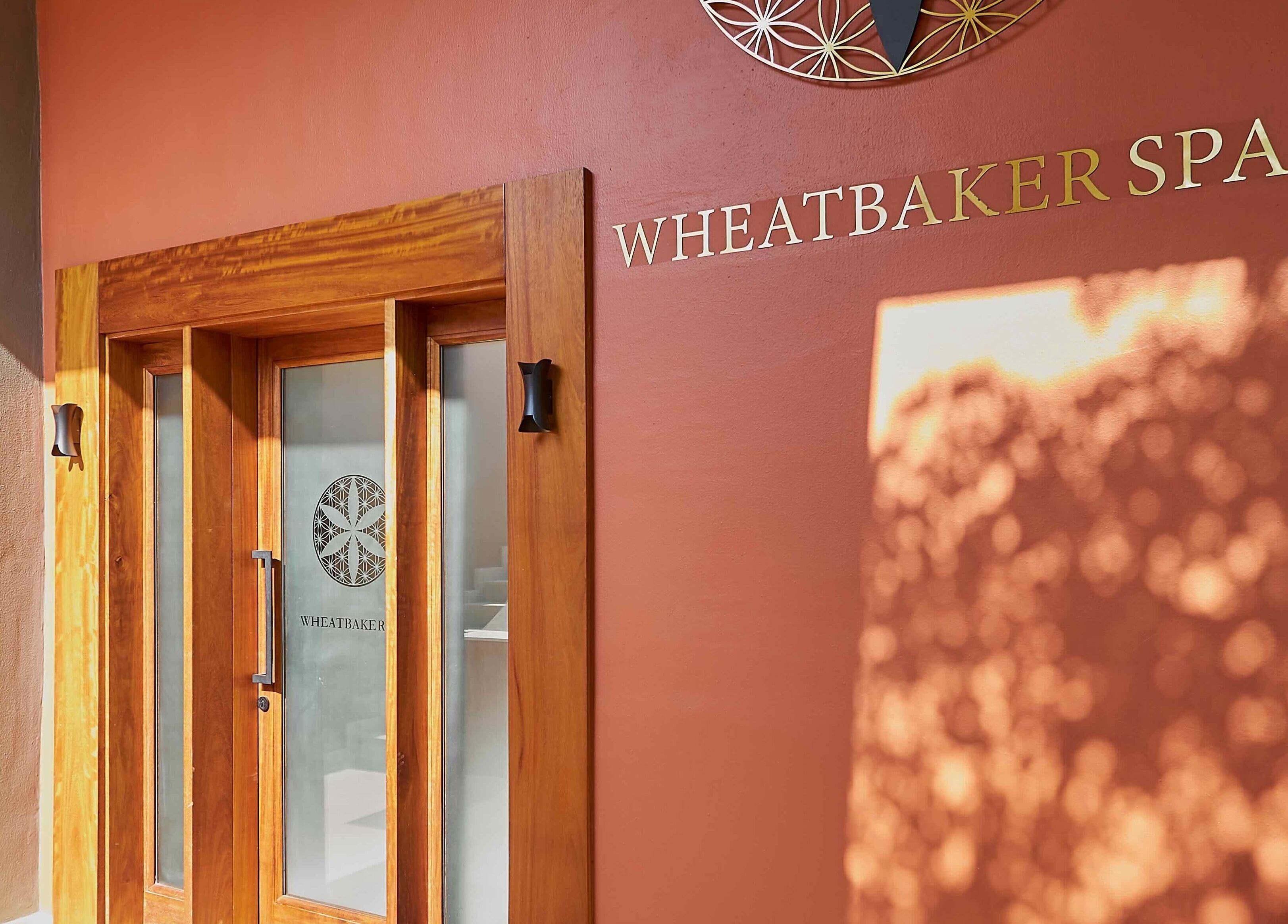 Entrance to The Wheatbaker Spa, Lagos, Lagos, NG with wooden door and spa logo.