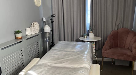 Relaxing treatment room at Youphoria Beauty Verwood, Verwood, England, GB, showcasing a cozy chair and massage bed.