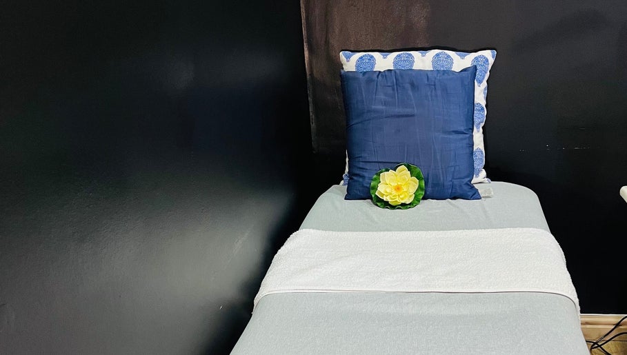 A tranquil treatment bed at Trends beauty bar, Cape Town, Western Cape, ZA, with plush cushions and decorative flower.