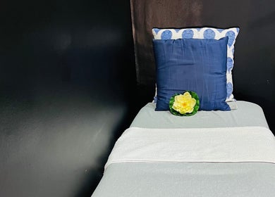 A tranquil treatment bed at Trends beauty bar, Cape Town, Western Cape, ZA, with plush cushions and decorative flower.