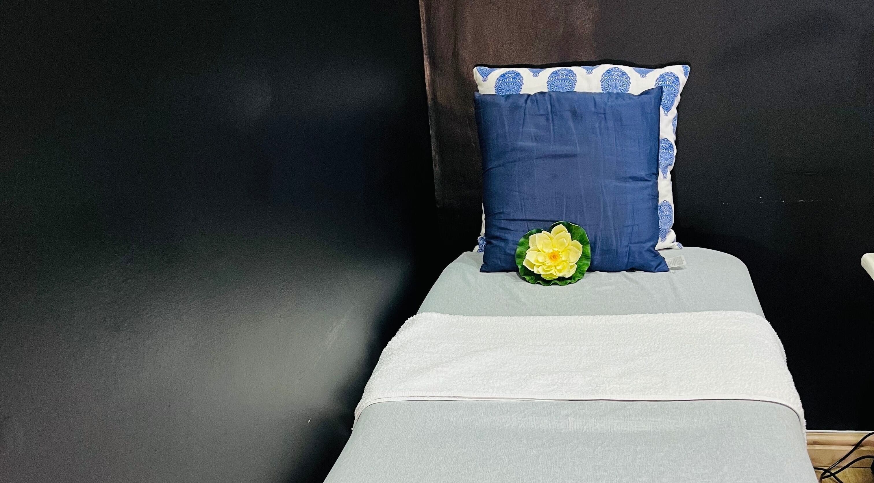 A tranquil treatment bed at Trends beauty bar, Cape Town, Western Cape, ZA, with plush cushions and decorative flower.