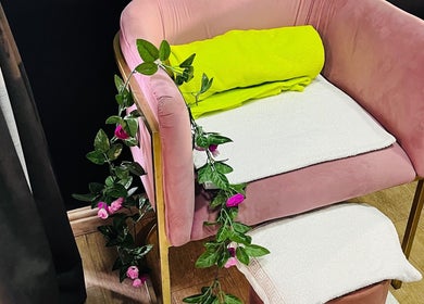 A plush pink chair adorned with green leaves at Trends Beauty Bar in Cape Town, Western Cape, ZA.