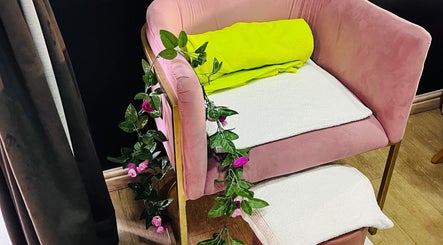 A plush pink chair adorned with green leaves at Trends Beauty Bar in Cape Town, Western Cape, ZA.