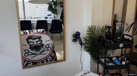 Modern interior of Redz Hedz Barbers in Goldthorpe, England featuring styling tools and a sleek mirror.