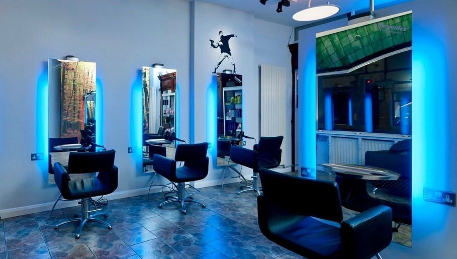 Modern salon interior at Lou Aldwick hair in Bognor Regis, England, GB with sleek chairs and illuminated mirrors.