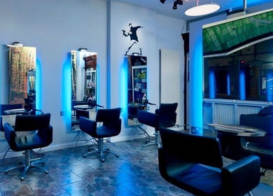 Modern salon interior at Lou Aldwick hair in Bognor Regis, England, GB with sleek chairs and illuminated mirrors.