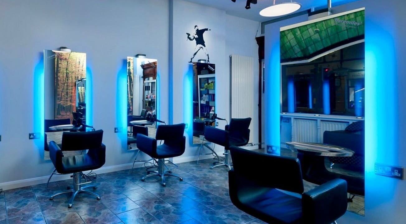 Modern salon interior at Lou Aldwick hair, Bognor Regis, England, GB featuring chic chairs and glowing mirrors.