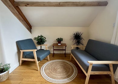 Cozy wellness seating area at Sacred Tree Wellness, Tiverton, England, GB featuring plants and wooden furniture.