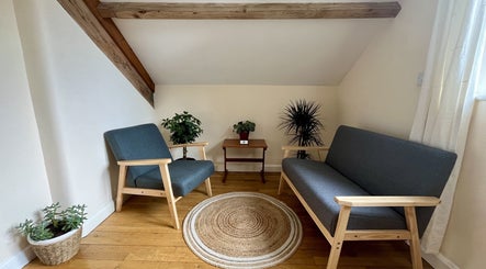 Cozy wellness seating area at Sacred Tree Wellness, Tiverton, England, GB featuring plants and wooden furniture.