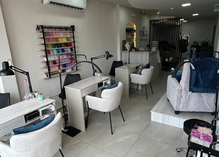Interior moderno de Nika Nails Spa en Guayaquil, Guayas, EC, mostrando estaciones de manicura elegantes.