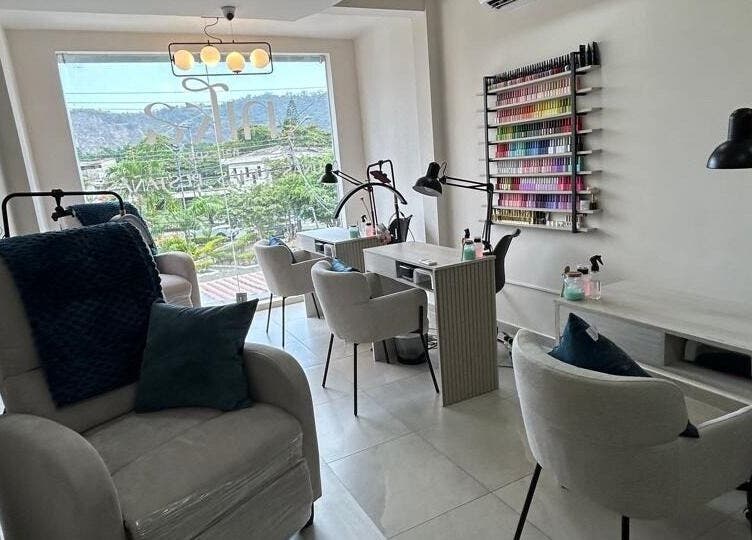 Interior de Nika Nails Spa en Guayaquil, Guayas, EC, mostrando cómodas sillas y una variedad de esmaltes.