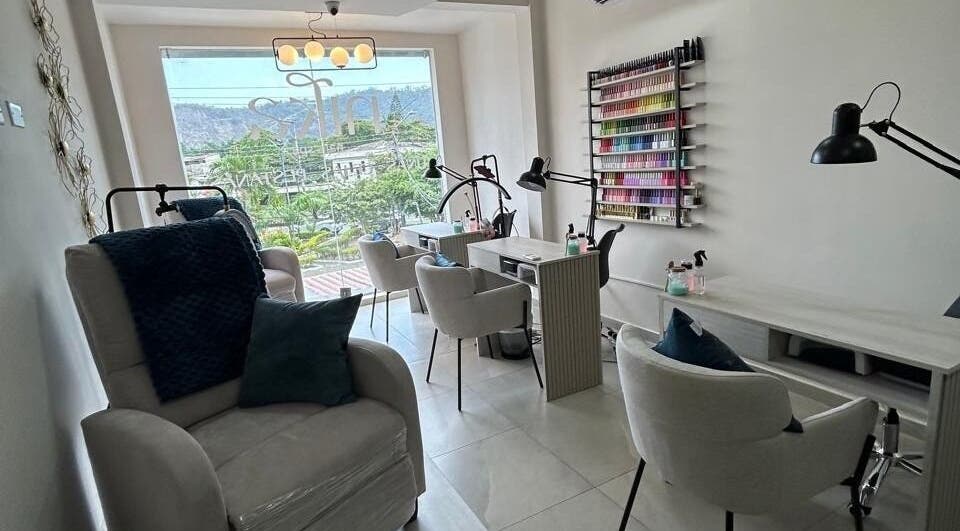 Interior de Nika Nails Spa en Guayaquil, Guayas, EC, mostrando cómodas sillas y una variedad de esmaltes.