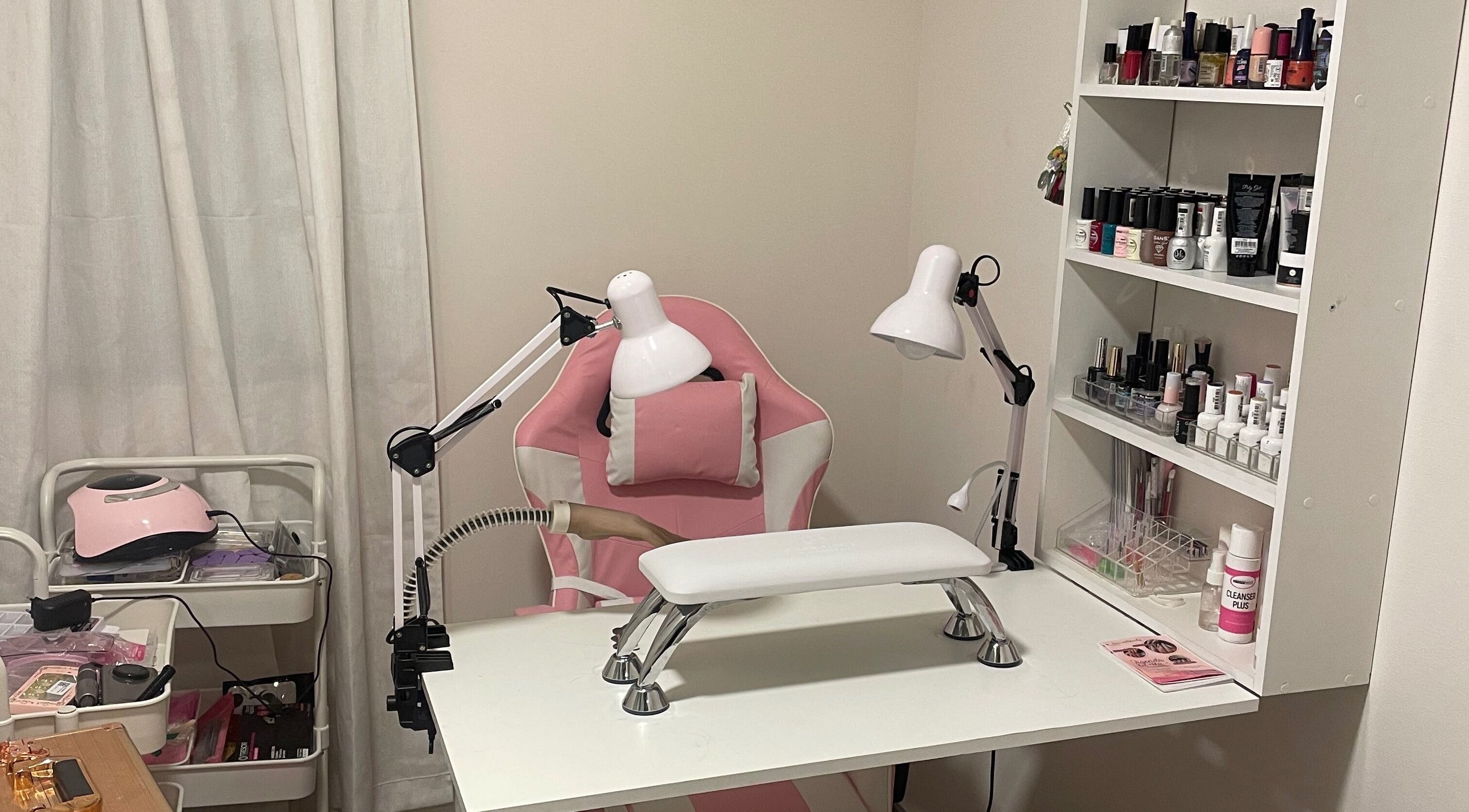 Moderno espacio de manicura en Artnailstudy, La Cisterna, Región Metropolitana, CL con silla y lámparas rosas.