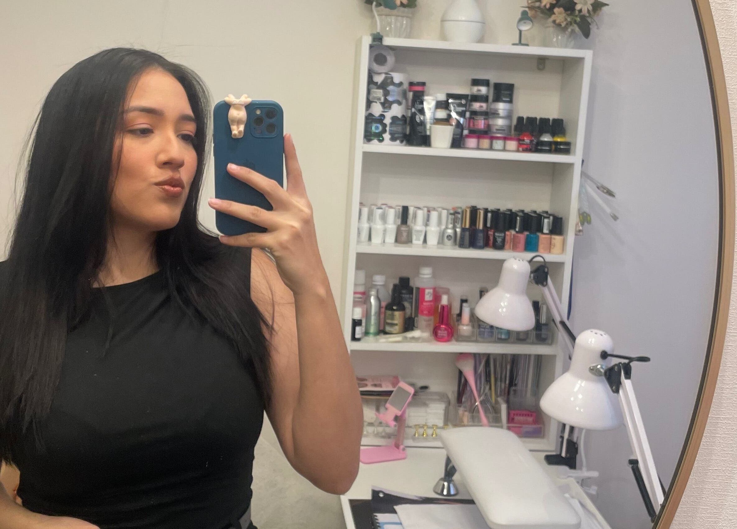 Vista del estudio Artnailstudy en La Cisterna, Región Metropolitana, CL, con estante de esmaltes y un espejo.