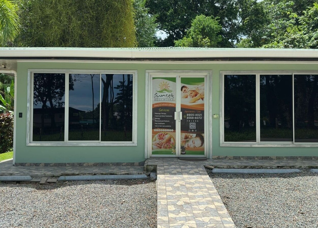 Front view of Sunset Body Works in Uvita, Provincia De Puntarenas, CR, surrounded by lush greenery.