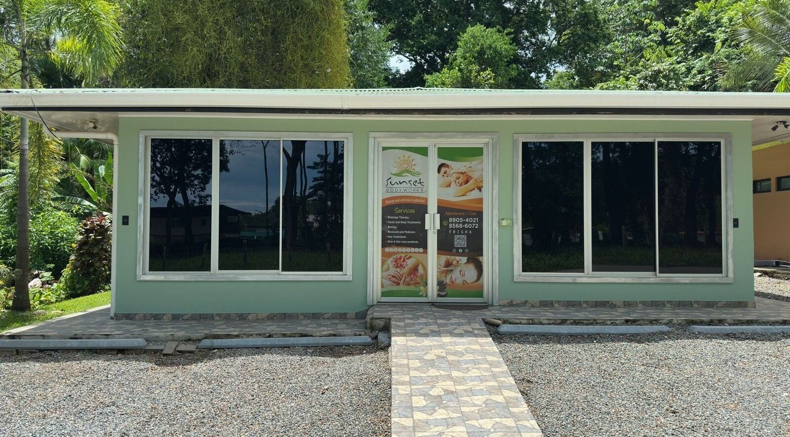 Front view of Sunset Body Works in Uvita, Provincia De Puntarenas, CR, surrounded by lush greenery.