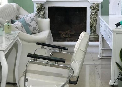 Zona de relax en Velvetwellnesscenter, Quito, Pichincha, EC con sillón blanco y decoración elegante.