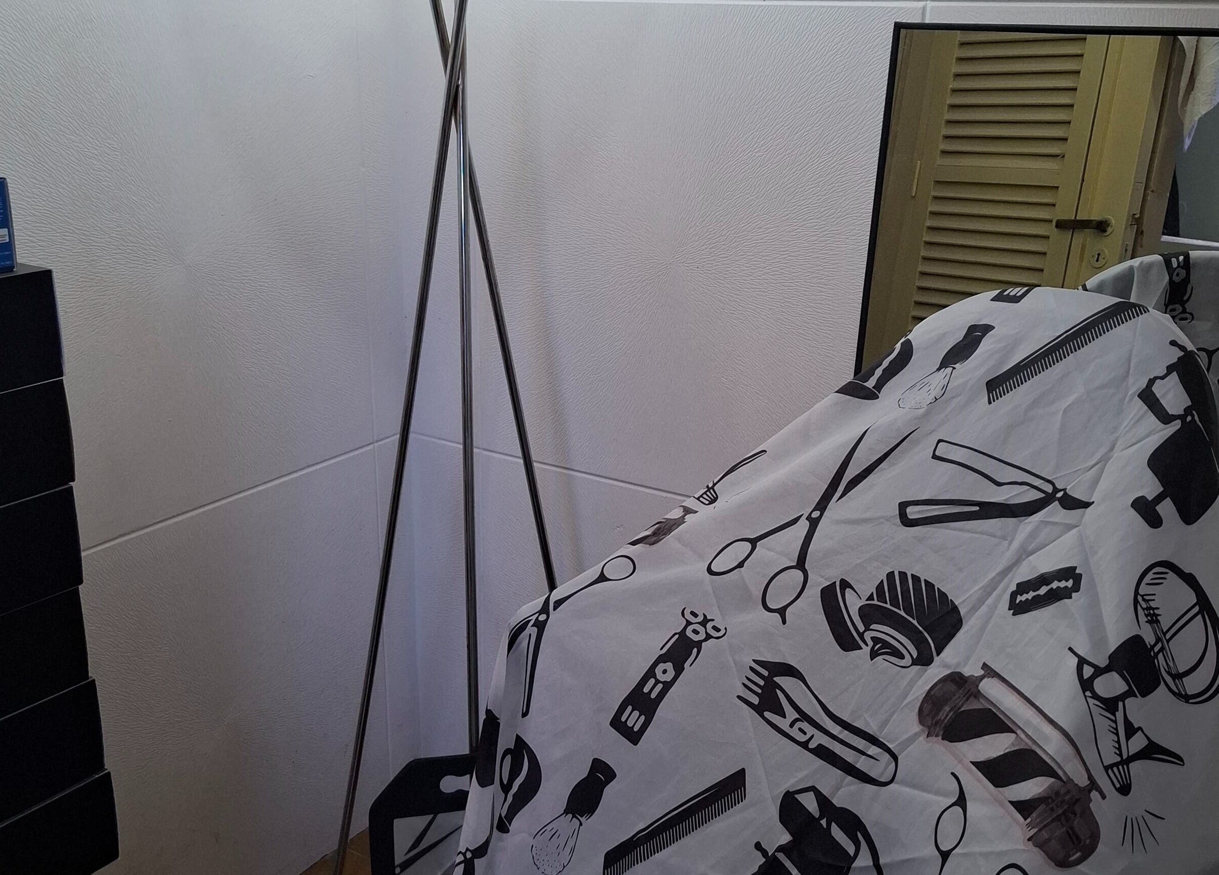 Rincón de barbería en JCStudio con espejo y funda estampada en Rosario, Santa Fe, AR.