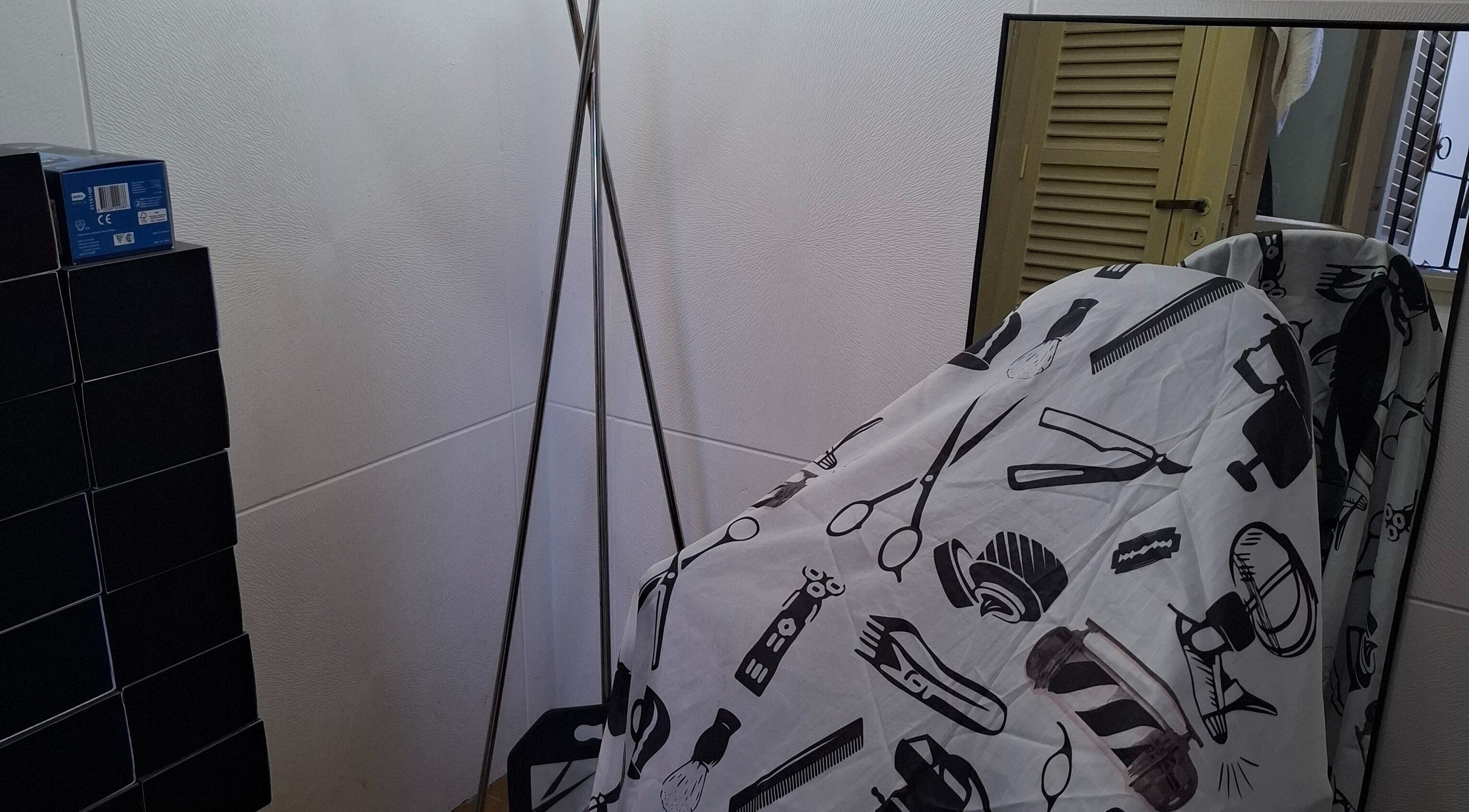 Rincón de barbería en JCStudio con espejo y funda estampada en Rosario, Santa Fe, AR.