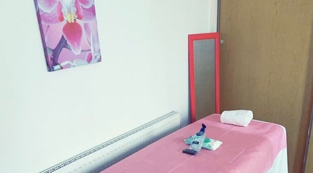 Clean waxing room at Brazil Waxing Woodside Park, London, England, GB with pink decor and a massage table.
