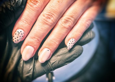 Polka dot nail art at Freedombeauty, Plymouth, England, GB. Elegant manicure with black dots on nude nails.