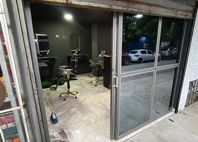 Vista del interior del Monarca Barber Club en Soledad, Atlántico, CO, mostrando sillones y espejos.