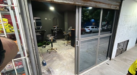 Vista del interior del Monarca Barber Club en Soledad, Atlántico, CO, mostrando sillones y espejos.