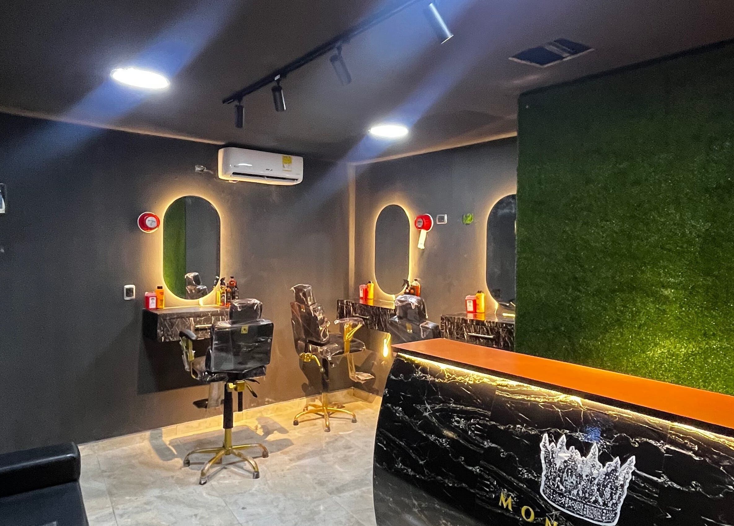 Interior moderno de Monarca Barber Club, Soledad, Atlántico, CO, con espejos iluminados y sillas de barbero.