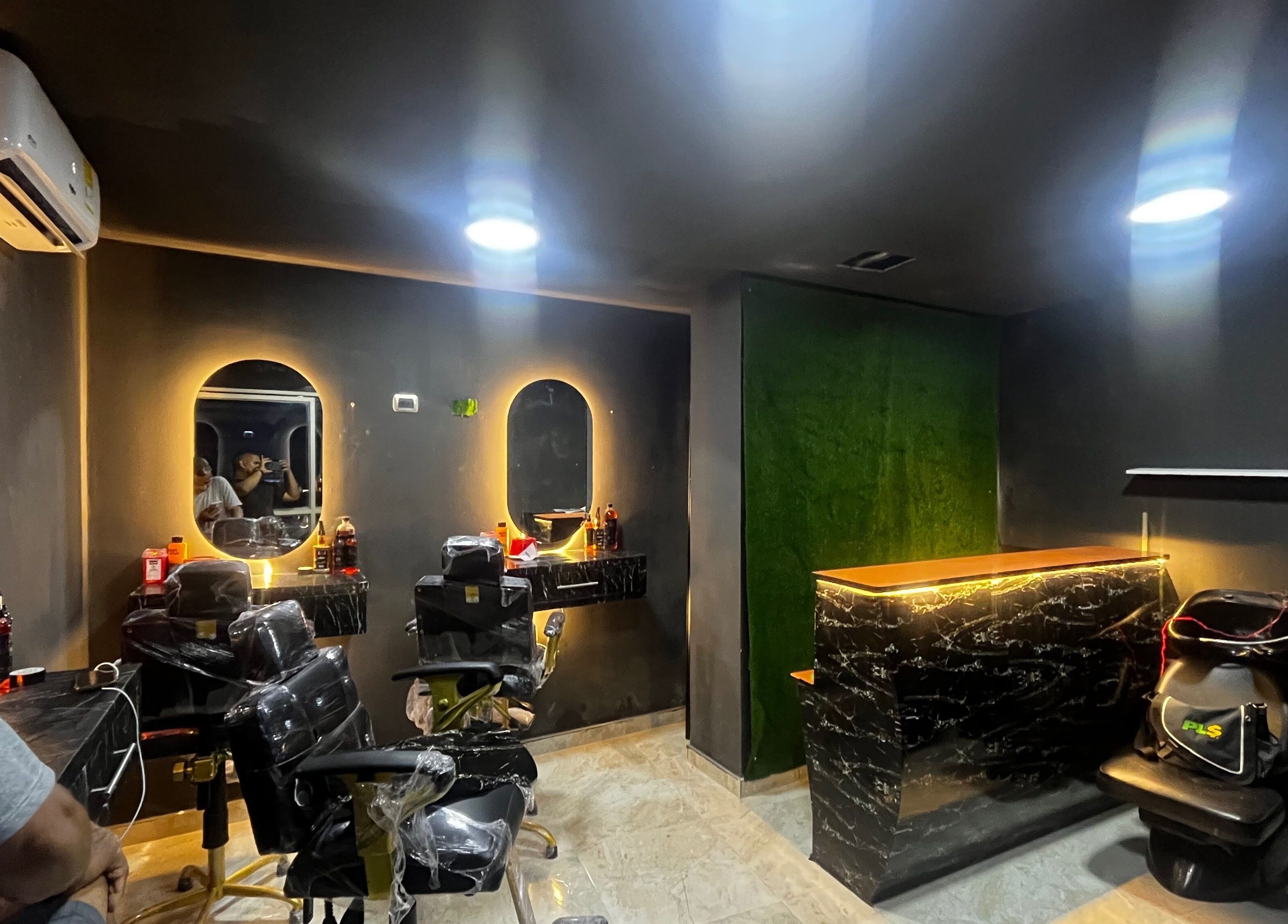 Interior elegante de Monarca Barber Club, Soledad, Atlántico, CO, mostrando sillas modernas y espejo iluminado.