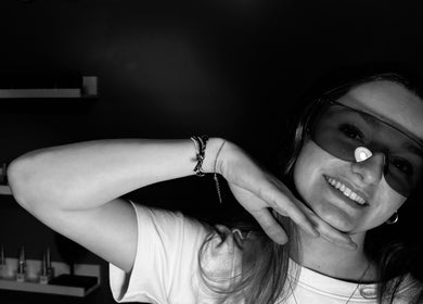 Client souriante portant des lunettes de protection chez Lou’nails, Aubrives, Grand Est, FR.