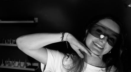 Client souriante portant des lunettes de protection chez Lou’nails, Aubrives, Grand Est, FR.