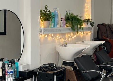 Modern salon interior at Andreea Arcalianu, Dagenham, England, GB with stylish chairs and illuminated decor.