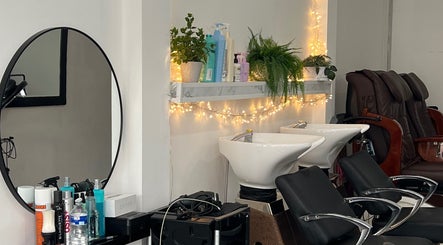 Modern salon interior at Andreea Arcalianu, Dagenham, England, GB with stylish chairs and illuminated decor.