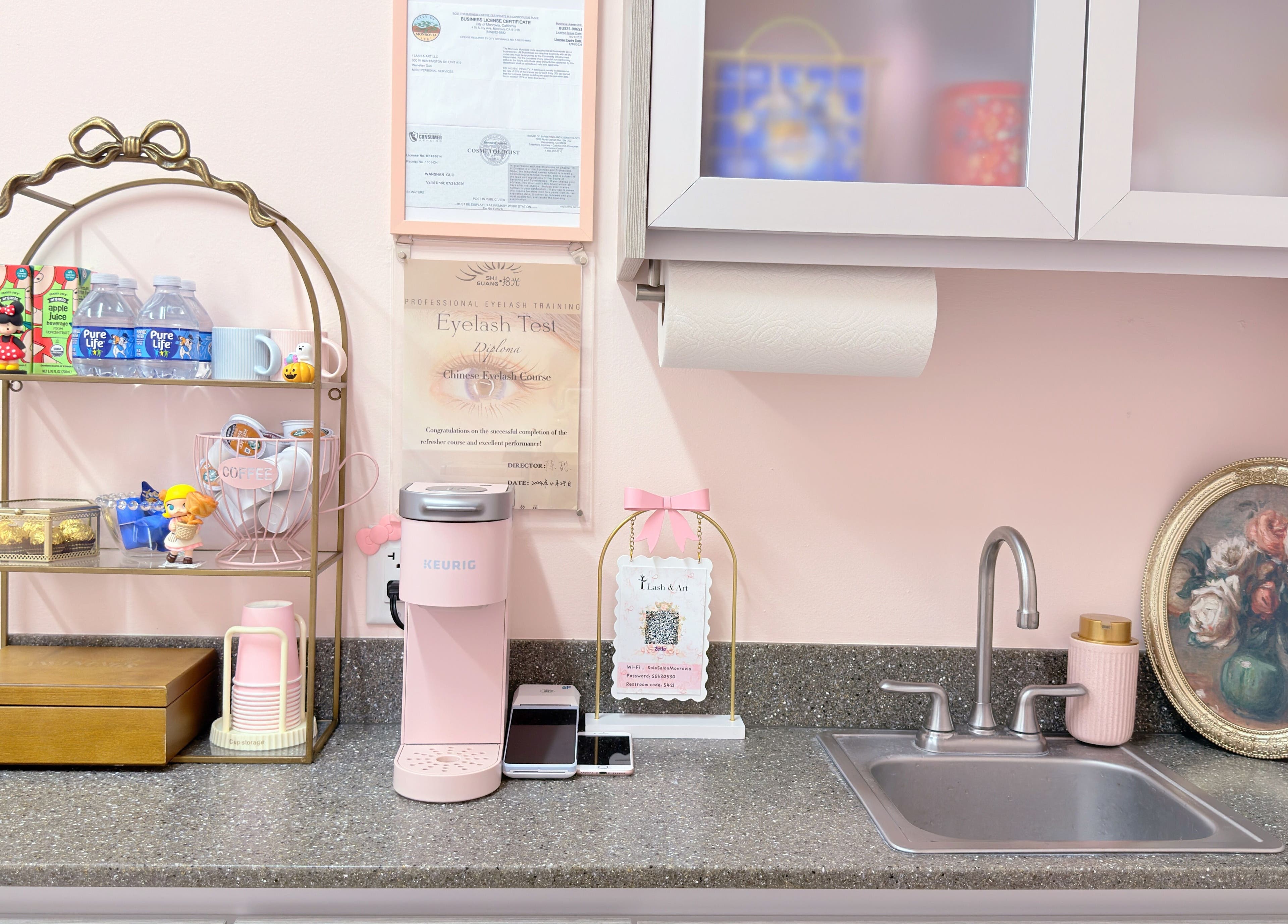 Cozy coffee corner at I Lash & Art, Monrovia, California with pink Keurig, decor, and sink.