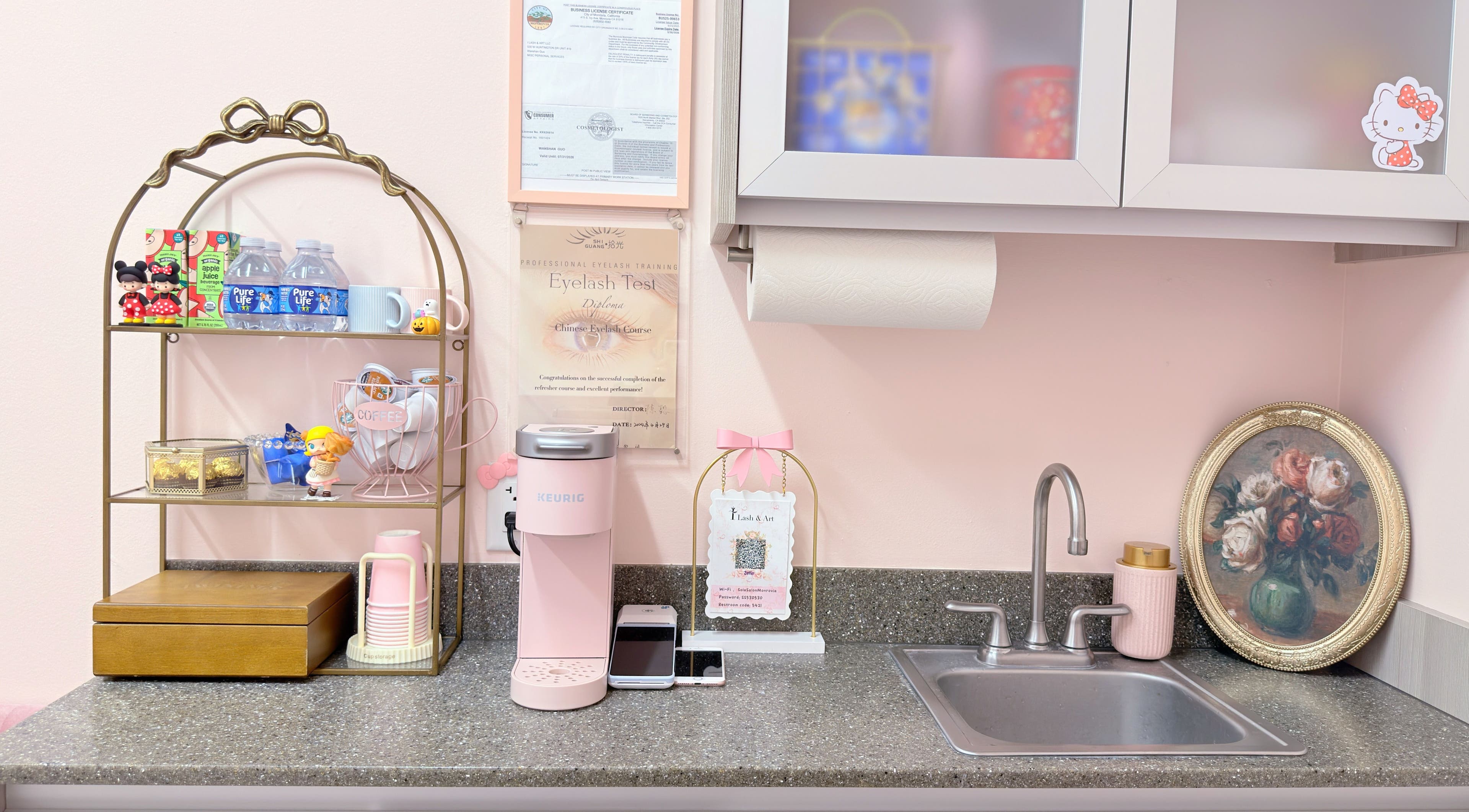 Cozy coffee corner at I Lash & Art, Monrovia, California with pink Keurig, decor, and sink.