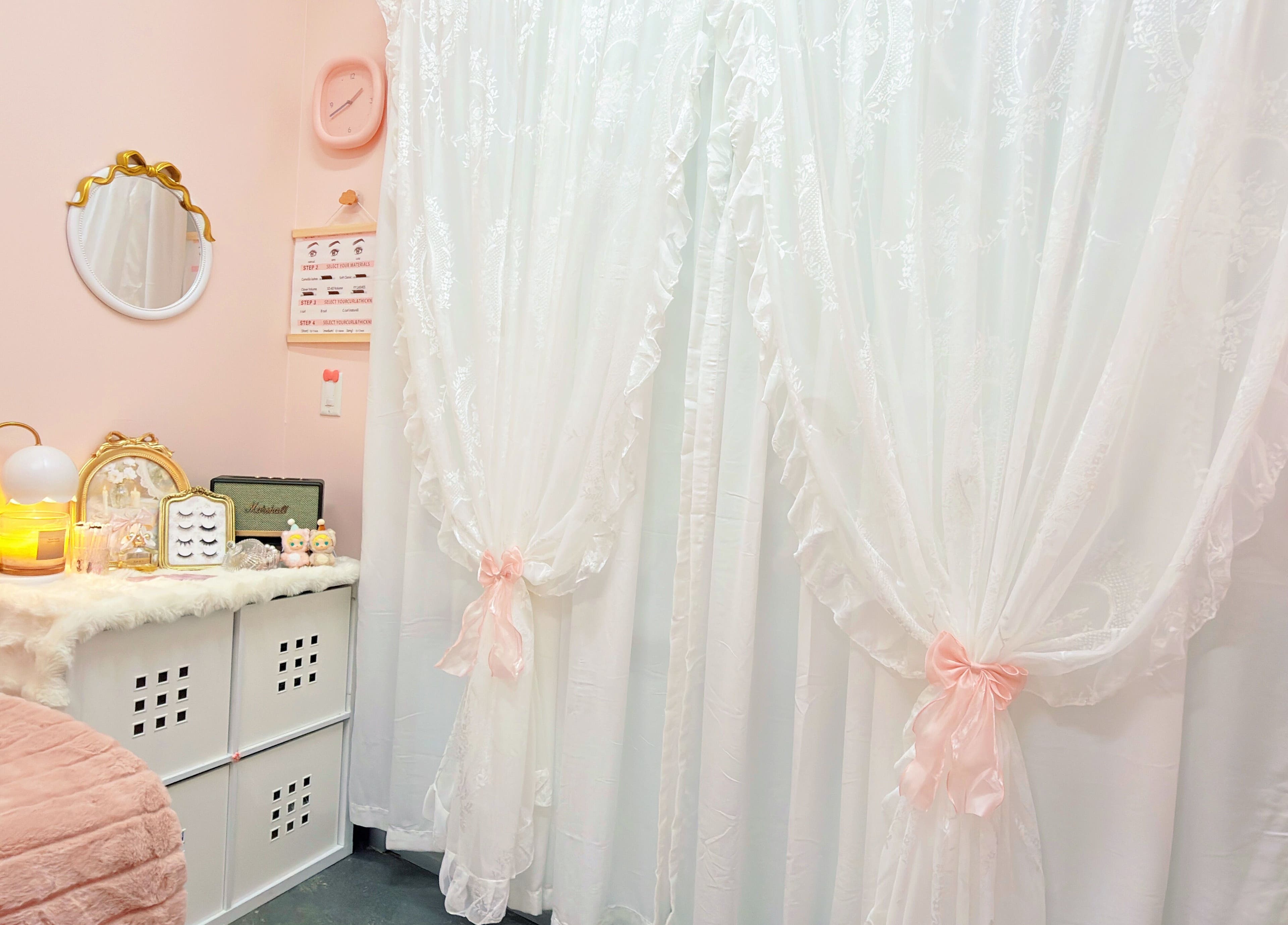 Elegantly decorated beauty room at I Lash & Art in Monrovia, California, US with plush bedding and white curtains.