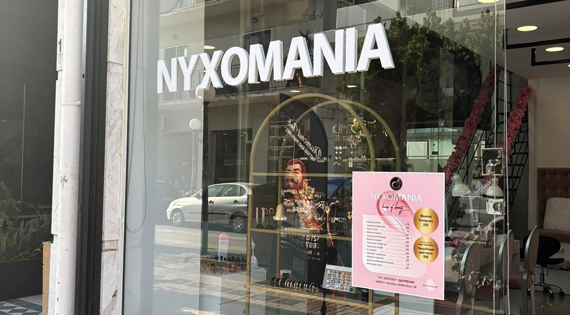 Η είσοδος του Νυχομανια Δάφνης στην Δάφνη Αττικής, GR με βιτρίνα και πινακίδα καταστήματος.