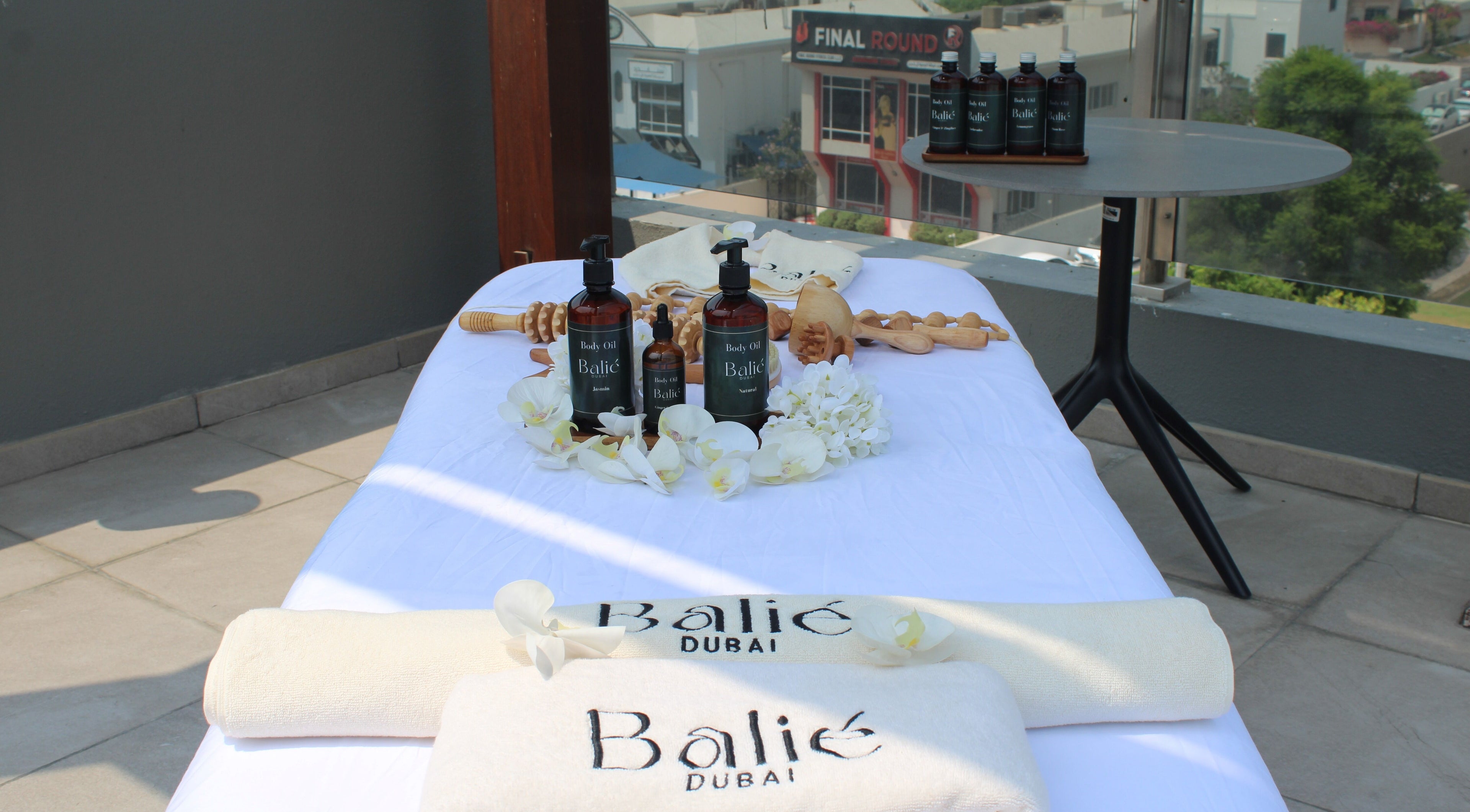 Spa massage table at Balié in Dubai, Dubai, AE, adorned with oils and orchids for a relaxing wellness experience.