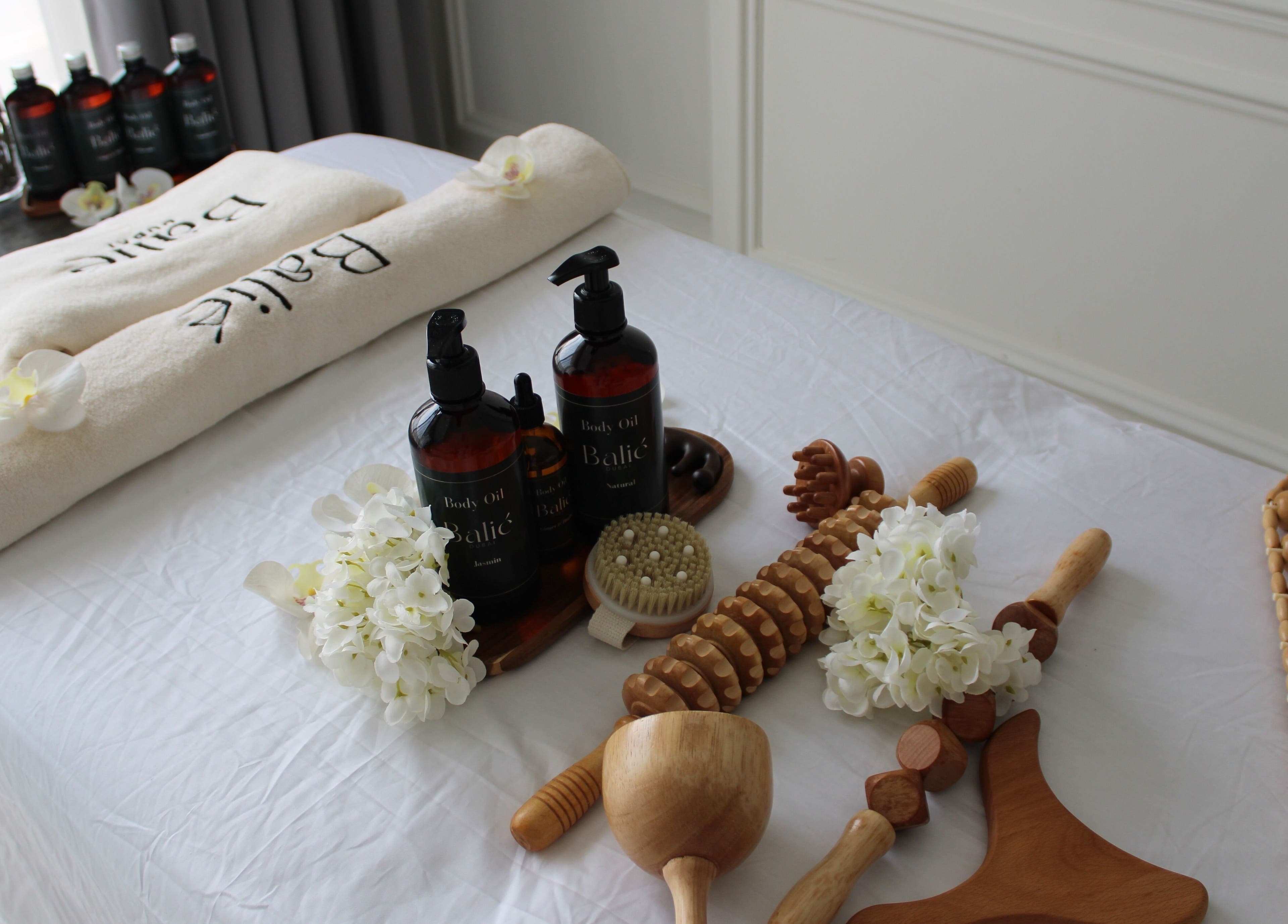 Elegant spa setup at Balié, Dubai, Dubai, AE with oils and white towels for a relaxing experience.