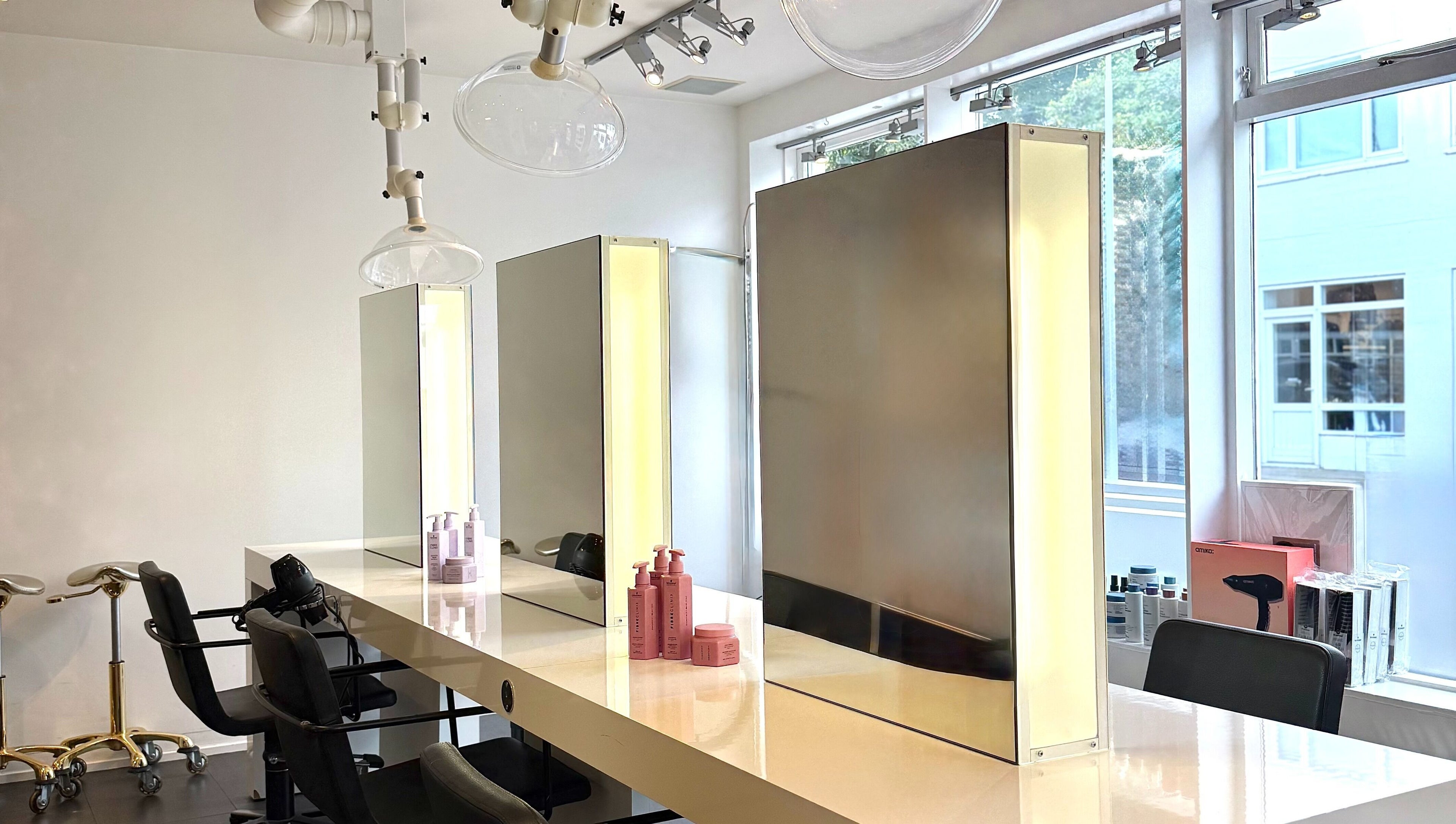 Modern styling stations at Salong Rót, Tórshavn, Streymoyar, FO, featuring sleek mirrors and luxury chairs.