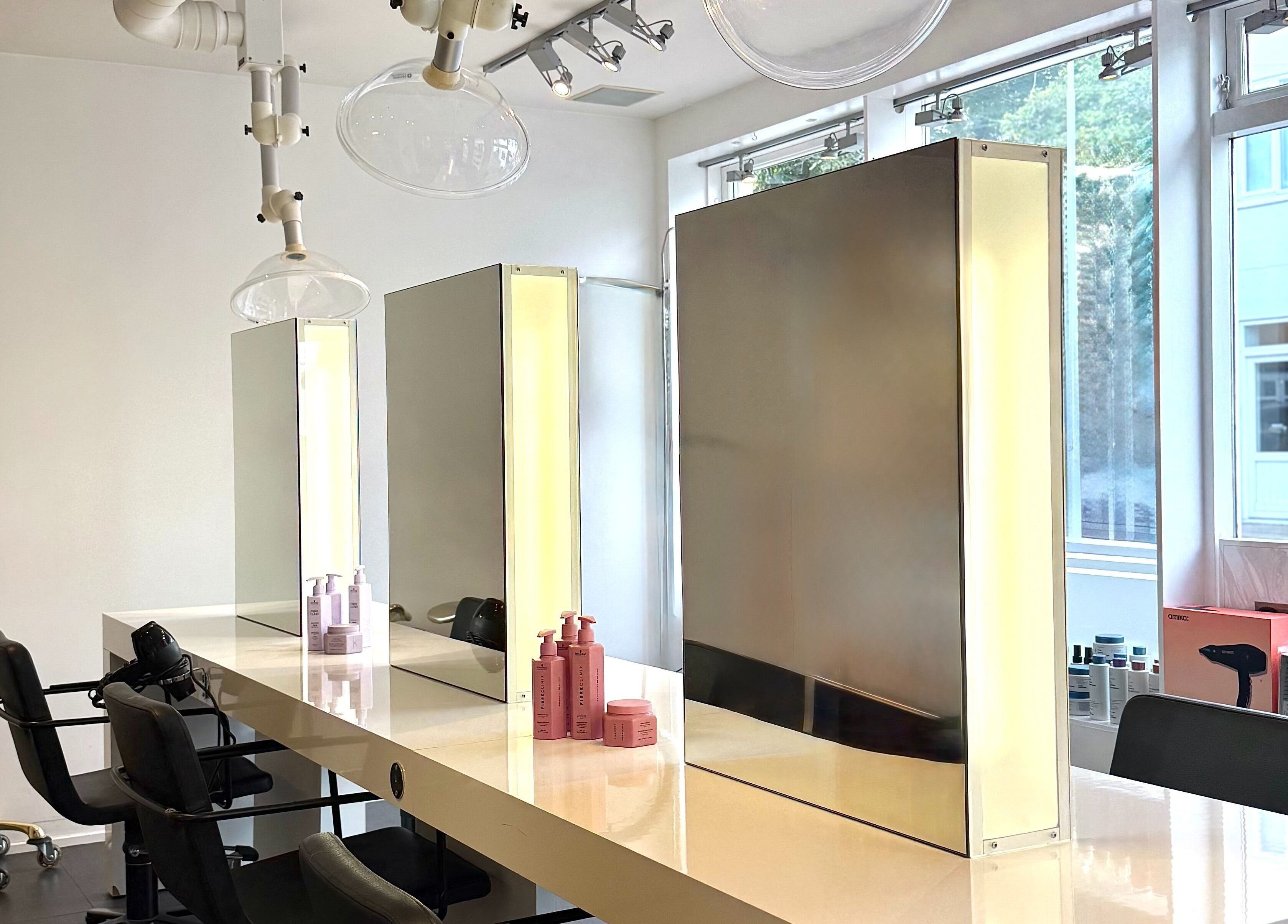 Modern styling stations at Salong Rót, Tórshavn, Streymoyar, FO, featuring sleek mirrors and luxury chairs.