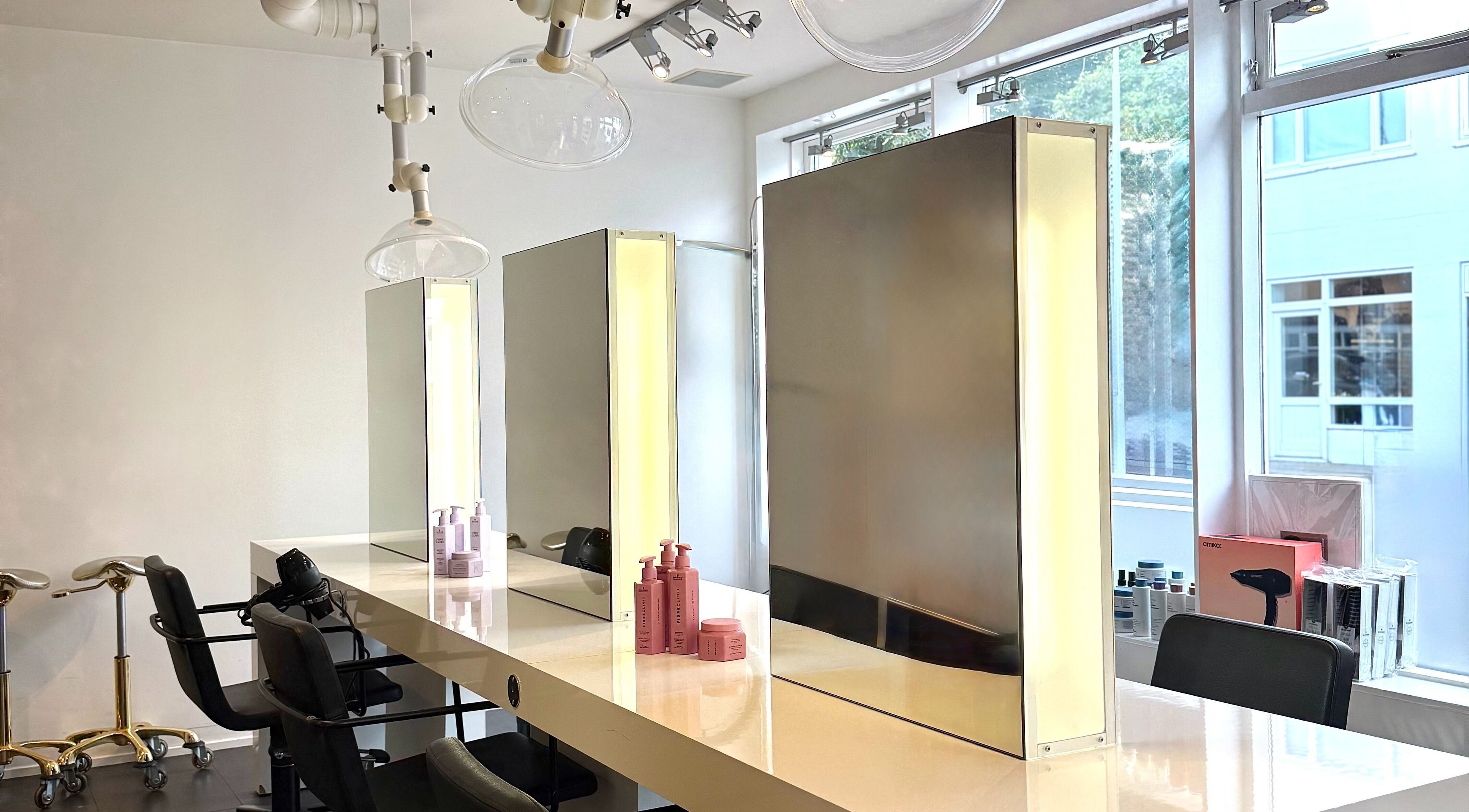 Modern styling stations at Salong Rót, Tórshavn, Streymoyar, FO, featuring sleek mirrors and luxury chairs.